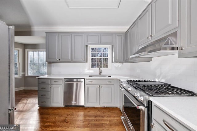 kitchen with gray cabinetry, dark wood-type flooring, sink, ornamental molding, and appliances with stainless steel finishes