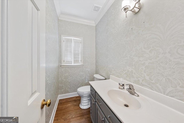 bathroom featuring hardwood / wood-style floors, vanity, toilet, and ornamental molding