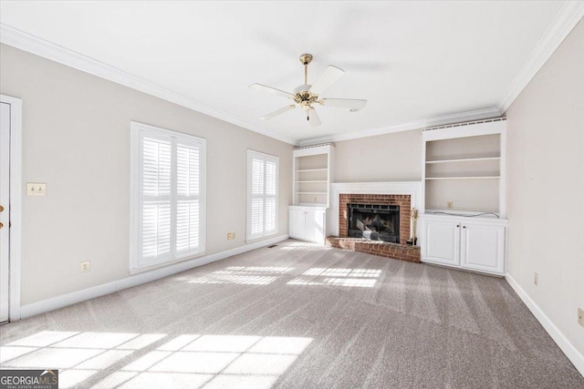 unfurnished living room featuring a fireplace, built in shelves, ceiling fan, and crown molding