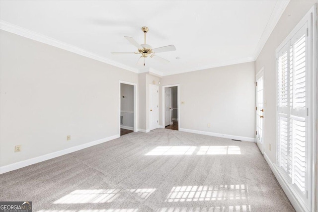 carpeted spare room with ceiling fan and crown molding