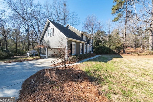 view of side of property with a lawn and a garage