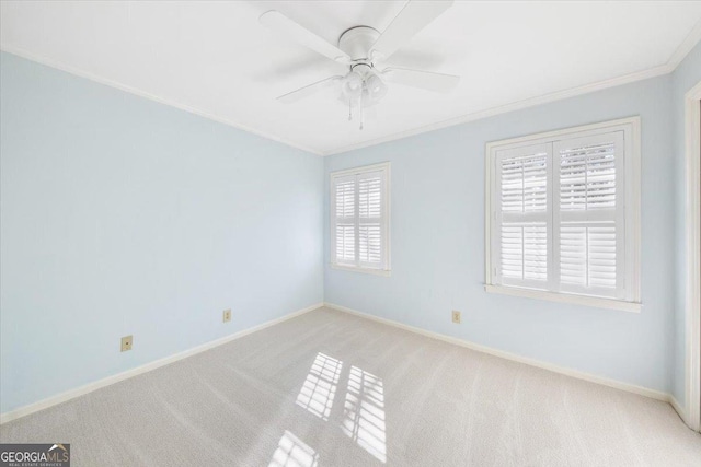 empty room featuring plenty of natural light, ceiling fan, light colored carpet, and crown molding