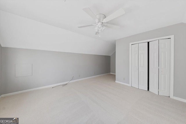 additional living space featuring light carpet, ceiling fan, and lofted ceiling