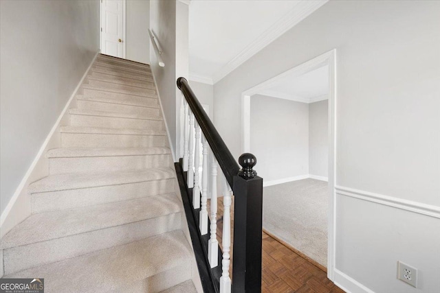 staircase with ornamental molding and parquet flooring