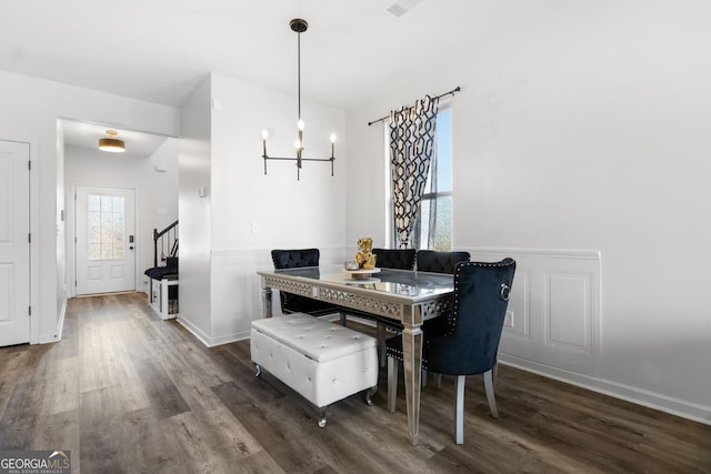 dining room featuring dark hardwood / wood-style flooring and an inviting chandelier