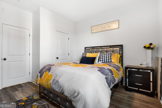 bedroom with dark hardwood / wood-style flooring