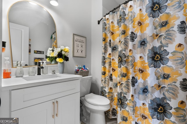 bathroom featuring a shower with curtain, vanity, and toilet