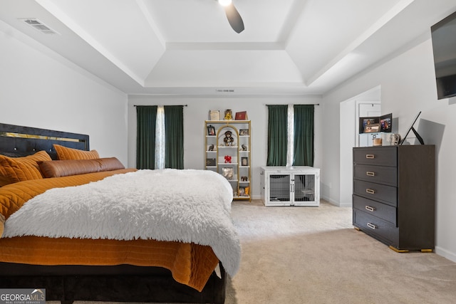 bedroom featuring a tray ceiling, ceiling fan, and light colored carpet