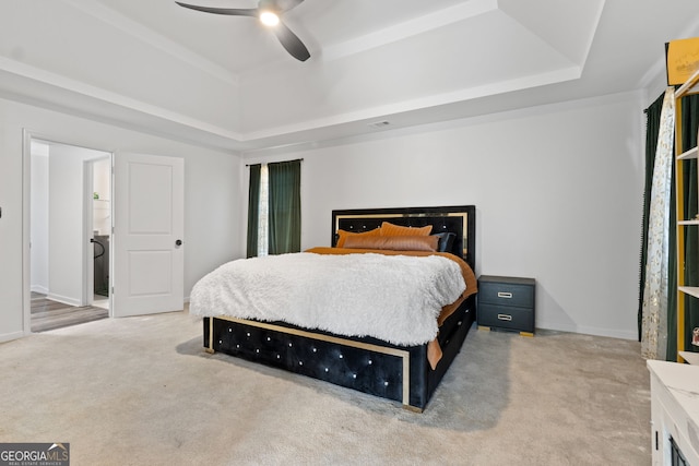 carpeted bedroom featuring a raised ceiling and ceiling fan