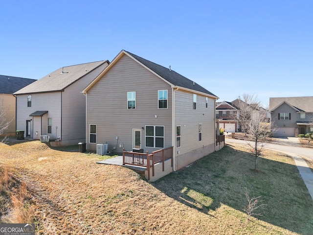 rear view of property featuring central AC and a yard