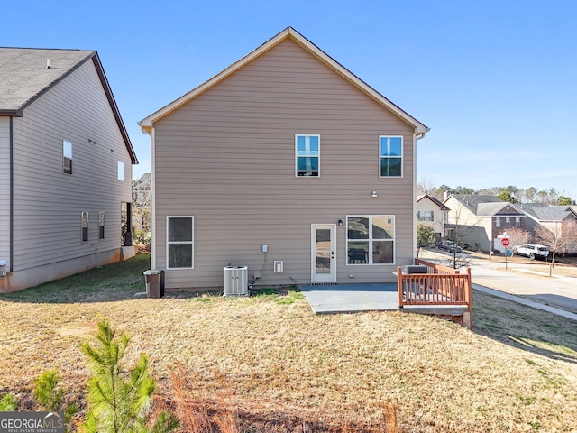 rear view of house featuring central AC unit, a patio area, and a lawn