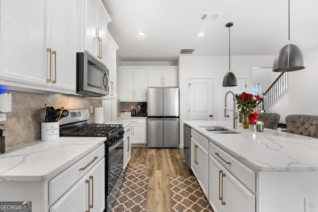 kitchen with white cabinetry, hanging light fixtures, and stainless steel appliances