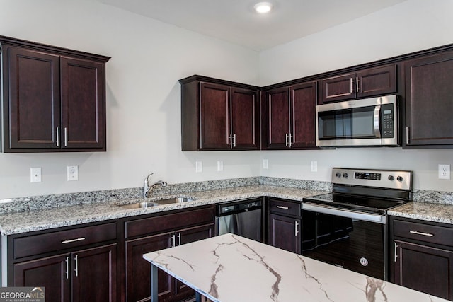 kitchen featuring light stone counters, sink, dark brown cabinets, and appliances with stainless steel finishes