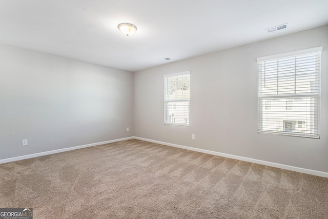 carpeted spare room featuring plenty of natural light