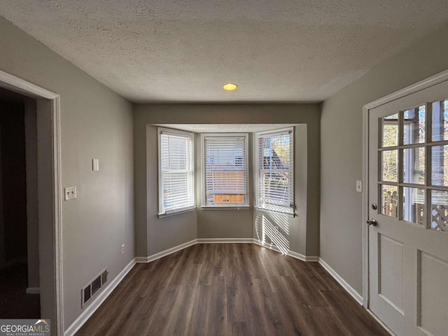 entryway featuring dark wood-type flooring and a textured ceiling