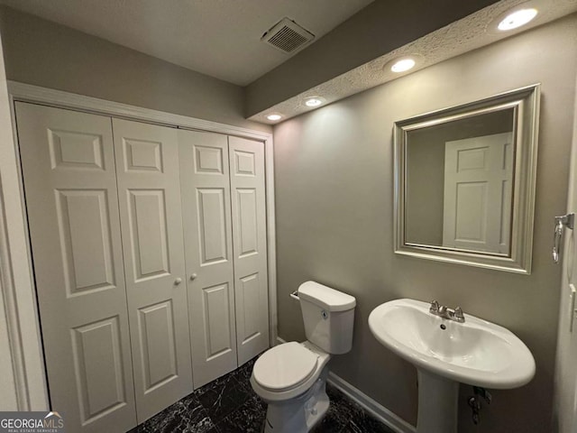 bathroom featuring toilet and sink