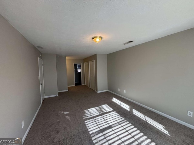 carpeted spare room featuring a textured ceiling