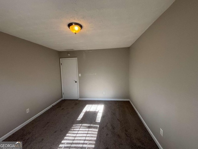 unfurnished room with a textured ceiling and carpet flooring