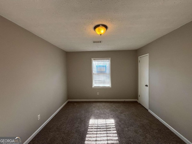 carpeted empty room featuring a textured ceiling