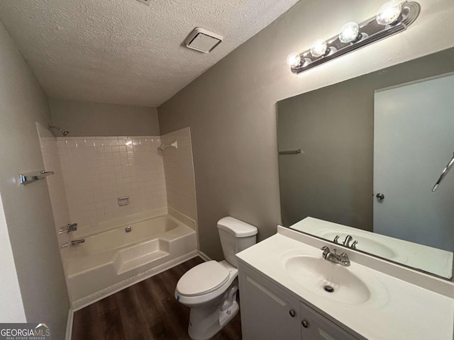 full bathroom with shower / washtub combination, toilet, wood-type flooring, vanity, and a textured ceiling