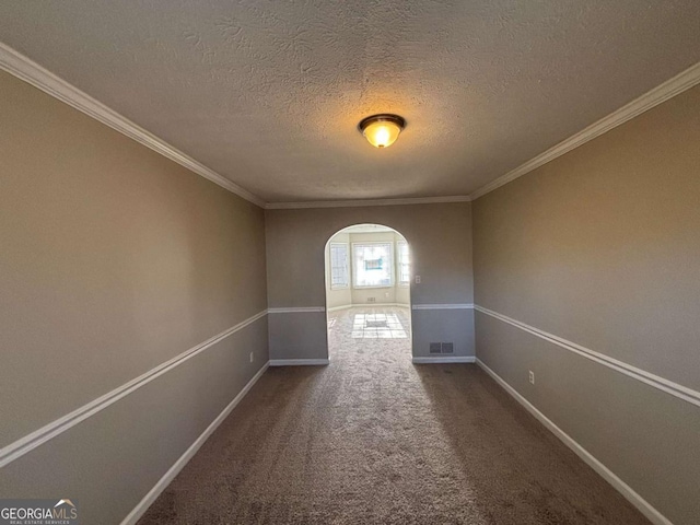 unfurnished room featuring a textured ceiling, ornamental molding, and carpet