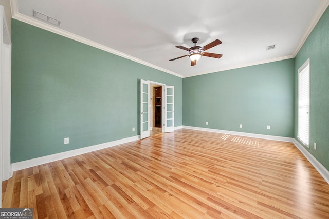 empty room featuring ceiling fan, crown molding, and light wood-type flooring