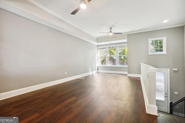 unfurnished living room featuring crown molding, ceiling fan, and dark wood-type flooring