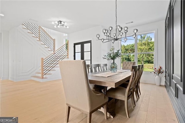 dining room featuring a chandelier, french doors, and light hardwood / wood-style floors