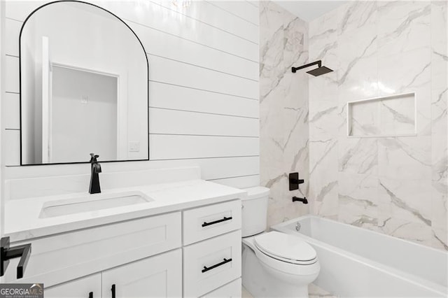 full bathroom with vanity, toilet, tiled shower / bath, and wooden walls