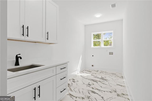 clothes washing area featuring cabinets, hookup for an electric dryer, and sink