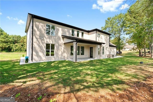 rear view of property with a yard and a patio