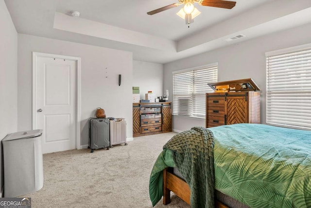 bedroom featuring carpet flooring, ceiling fan, and a raised ceiling