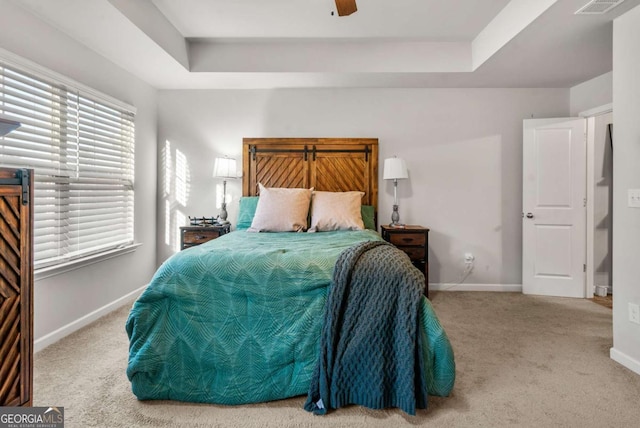 bedroom featuring carpet, ceiling fan, and a tray ceiling