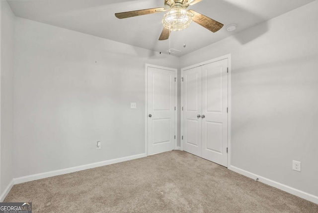 unfurnished bedroom with a closet, ceiling fan, and light colored carpet