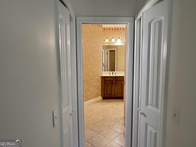 hallway featuring sink and light tile patterned floors