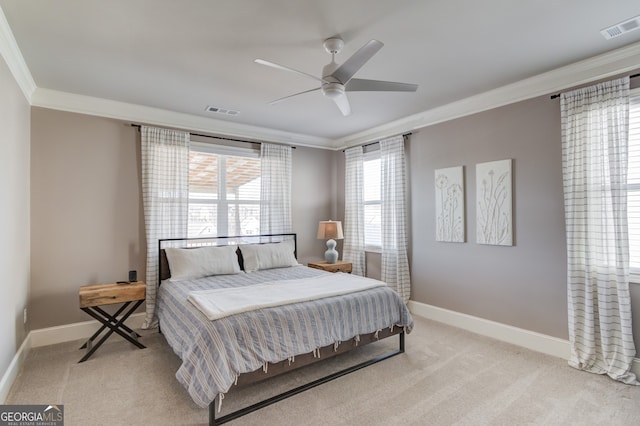 carpeted bedroom featuring ceiling fan and crown molding