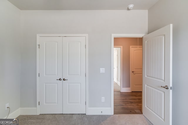 unfurnished bedroom featuring light carpet and a closet