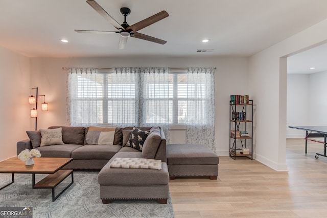 living room featuring ceiling fan and light hardwood / wood-style floors