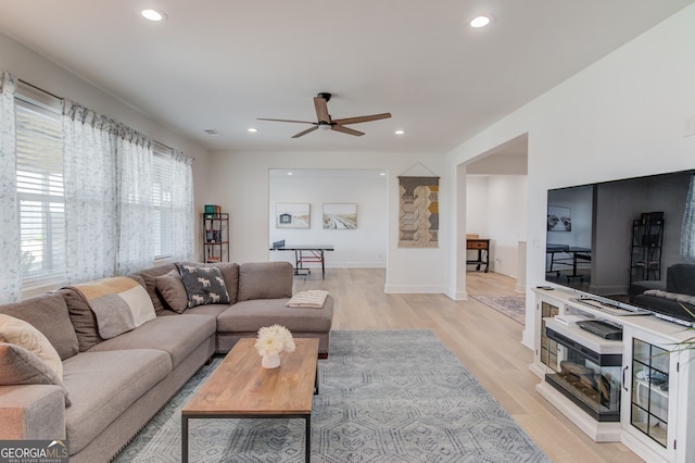 living room featuring ceiling fan and light hardwood / wood-style floors