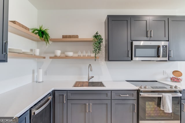 kitchen with gray cabinetry, sink, and appliances with stainless steel finishes