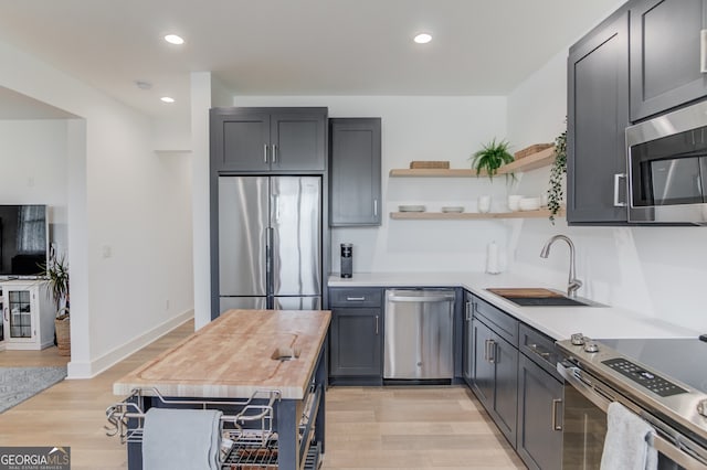 kitchen with light wood-type flooring, sink, and appliances with stainless steel finishes