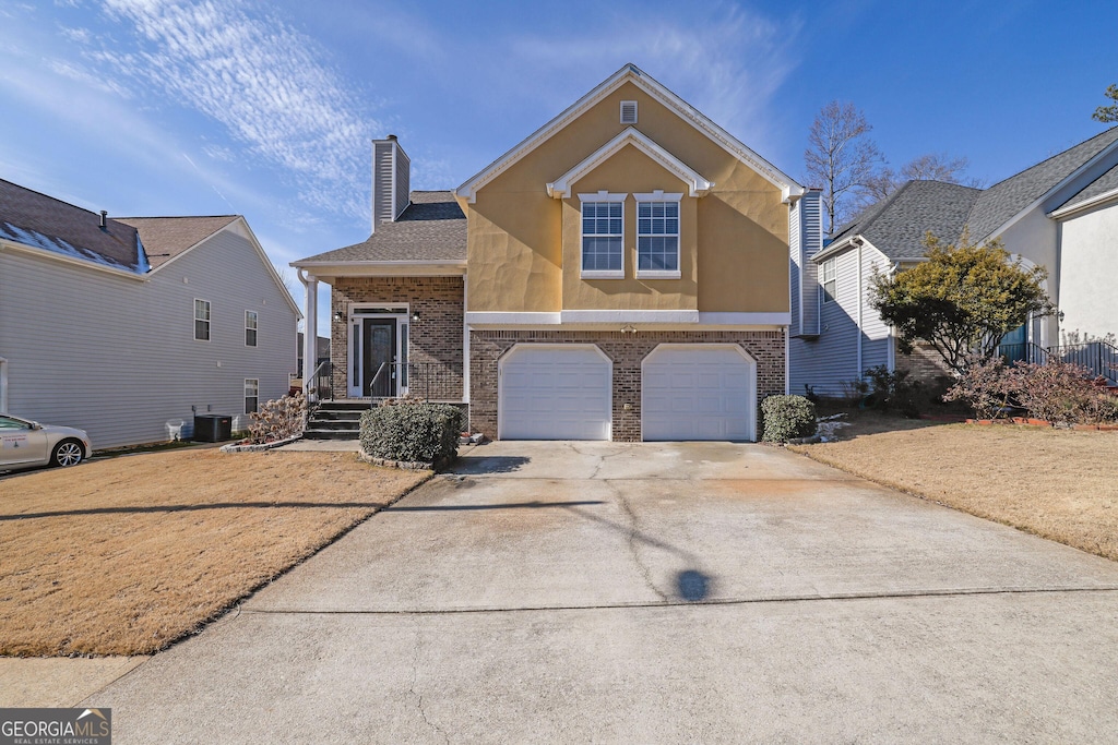 view of front of property featuring central AC and a garage