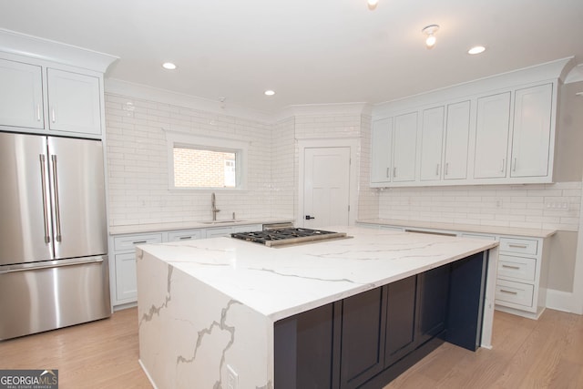 kitchen with white cabinets, a kitchen island, sink, and appliances with stainless steel finishes