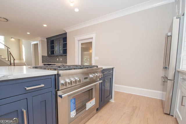 kitchen featuring decorative backsplash, light stone counters, high end appliances, crown molding, and light hardwood / wood-style floors