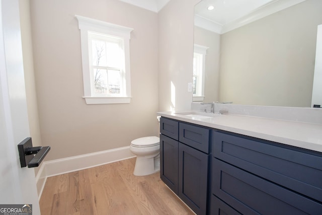 bathroom featuring hardwood / wood-style flooring, vanity, toilet, and crown molding