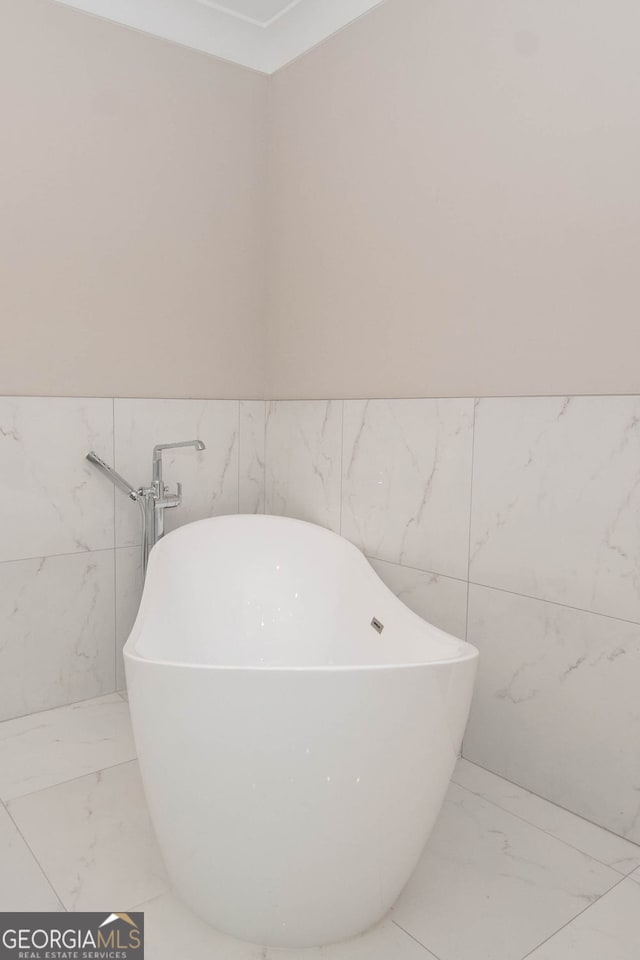 bathroom featuring a tub to relax in and tile walls