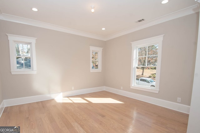 empty room featuring light wood-type flooring and ornamental molding