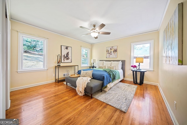 bedroom featuring ceiling fan, light hardwood / wood-style floors, and ornamental molding