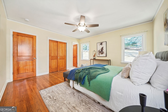 bedroom featuring hardwood / wood-style floors, ceiling fan, and ornamental molding