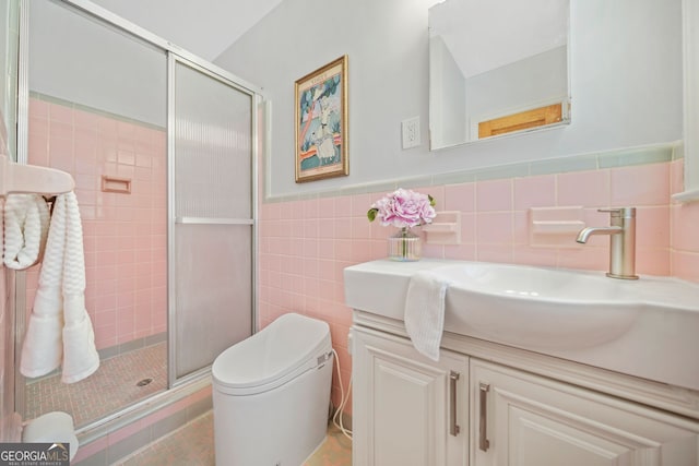 bathroom featuring vanity, toilet, a shower with shower door, and tile walls